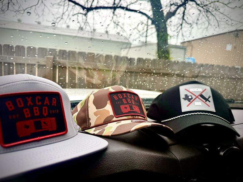 Three Boxcar BBQ patch caps on a dashboard