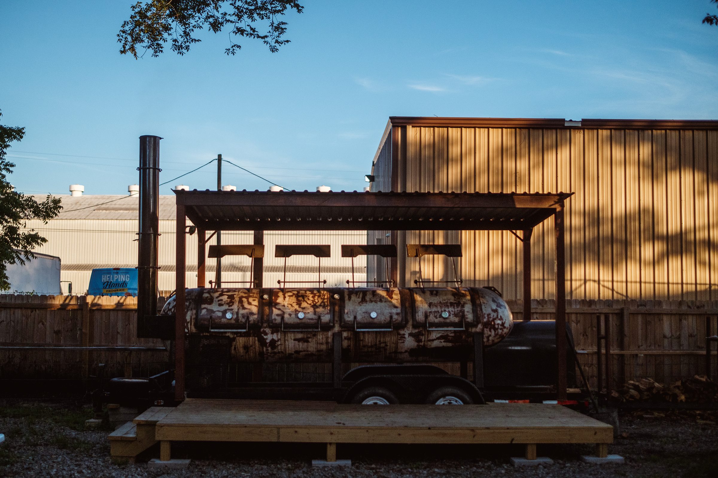 Smoker trailer under its shed roof on a clear afternoon